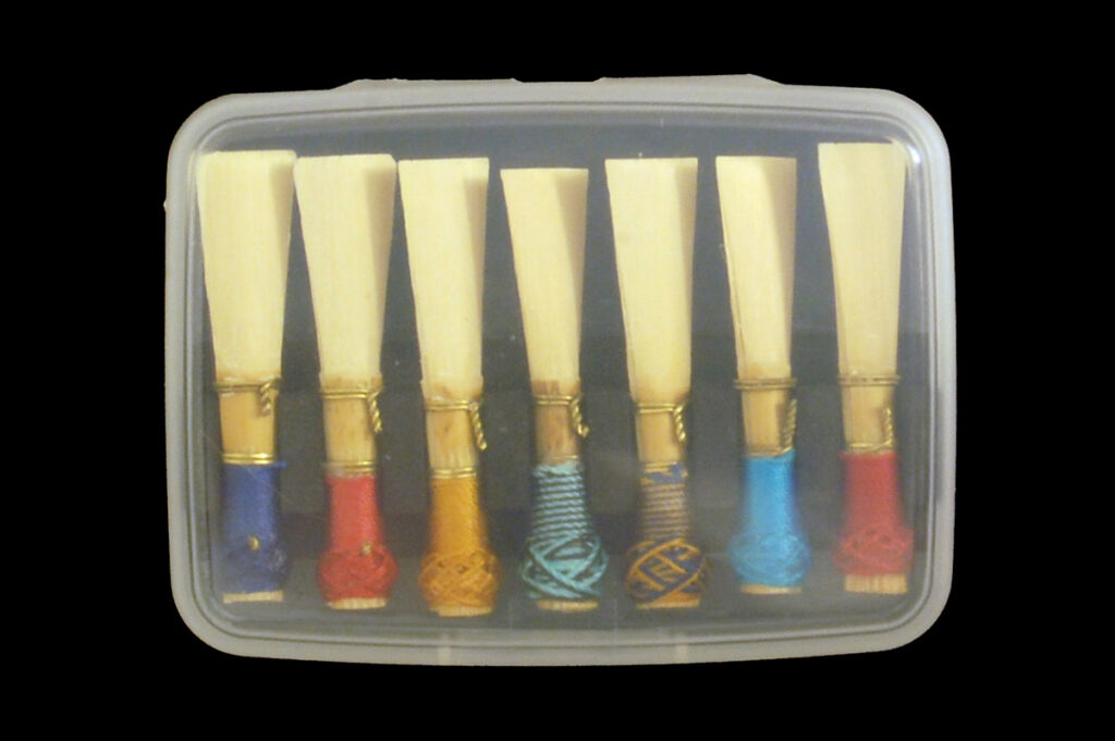 A clear plastic bassoon reed case holding seven reeds